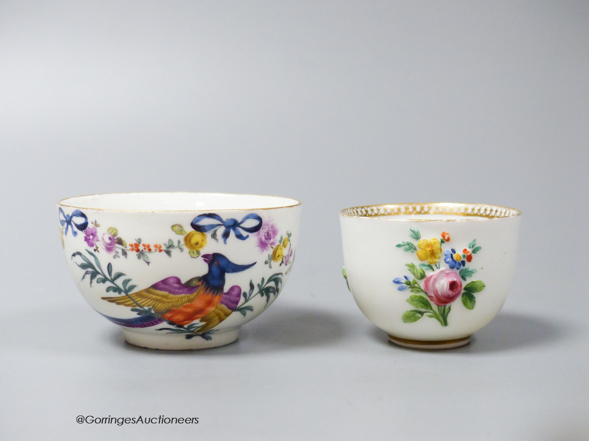 A Meissen bowl, c.1750, moulded and painted with flowers, 6cm diameter and Meissen cup, c.1750 painted with a parrot and flowers (2)